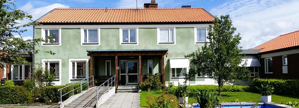 Ett hus med en fontän framför.