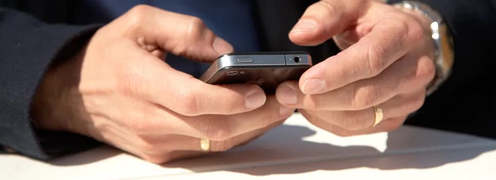 En närbild av en person som använder en mobiltelefon.