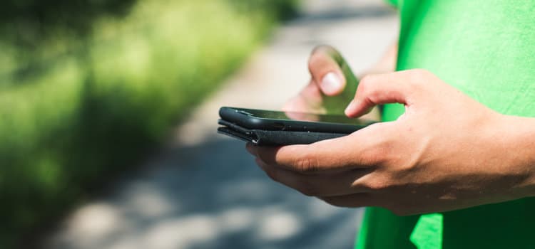 En person som håller en mobiltelefon i handen