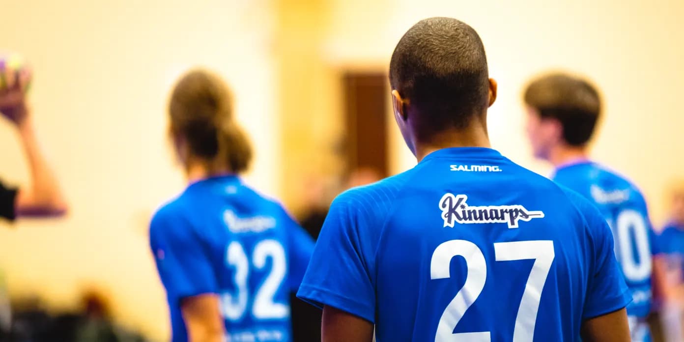 En grupp män som står bredvid varandra på en handbollsplan.