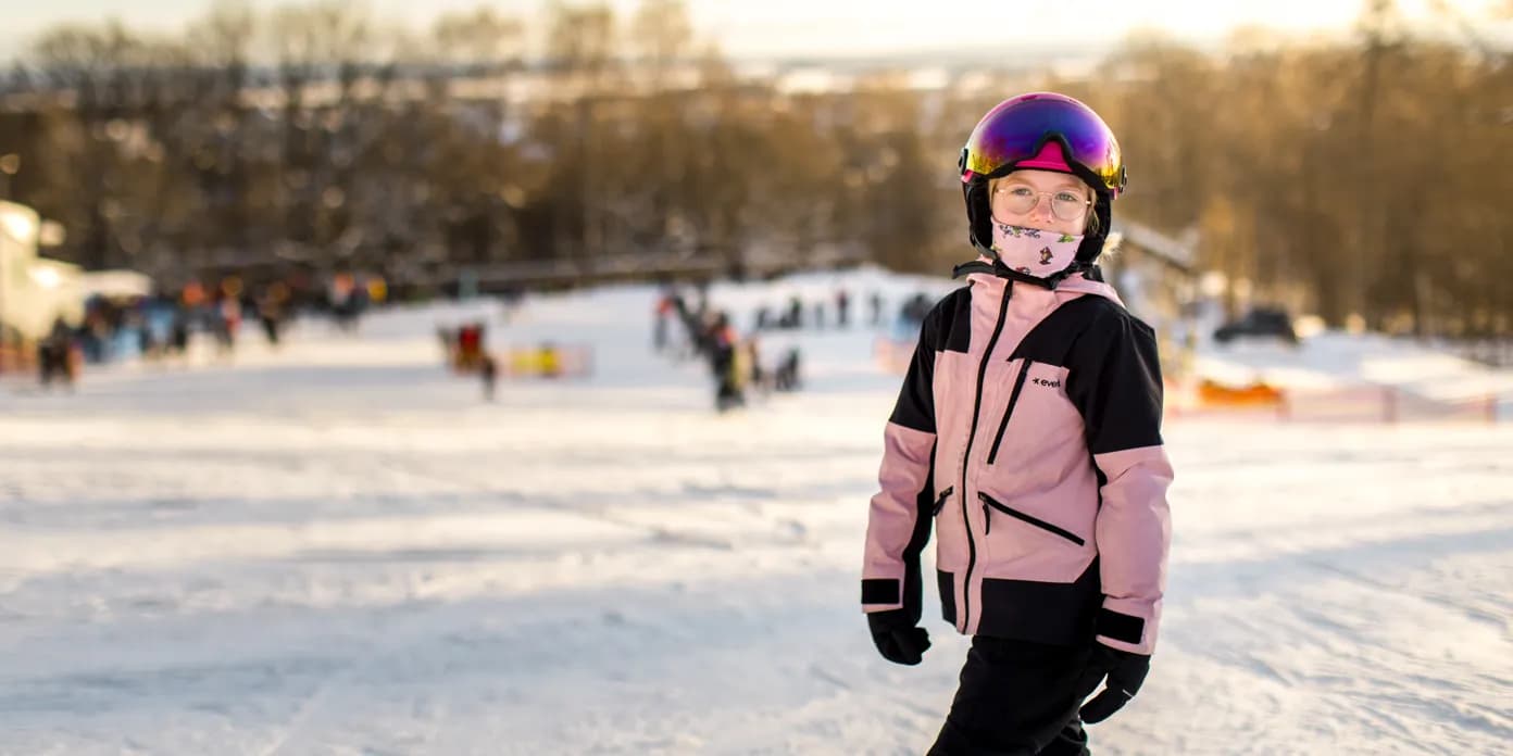 En tjej i rosa jacka som åker skidor i Billingebacken.