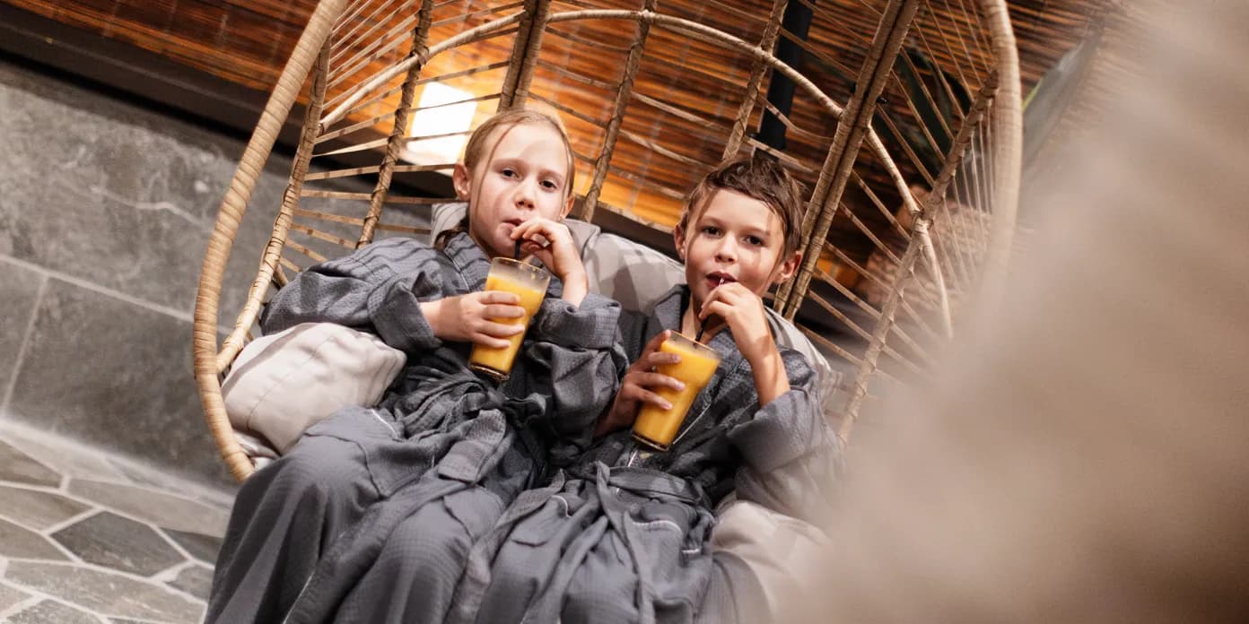 Två barn som dricker smoothie i en loungestol på Aqua Vitalis.