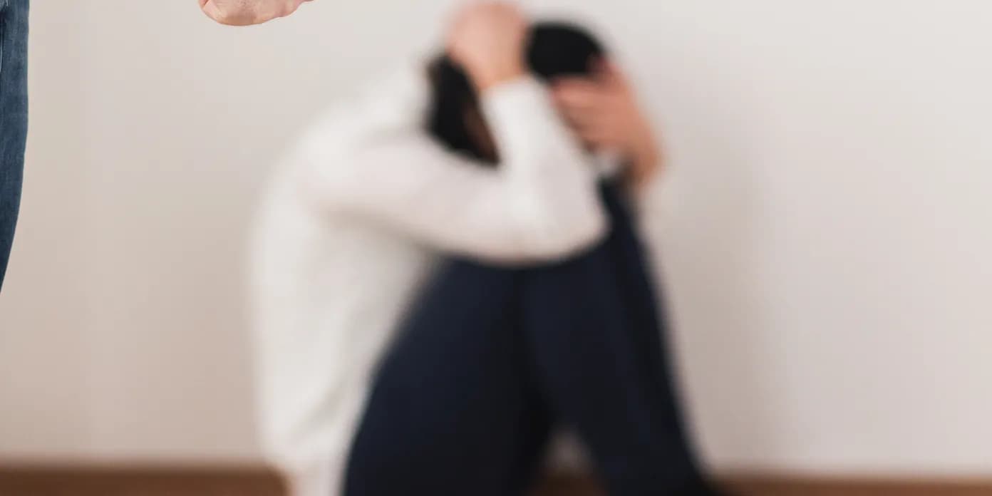 En man som står bredvid en kvinna som sitter på golvet.