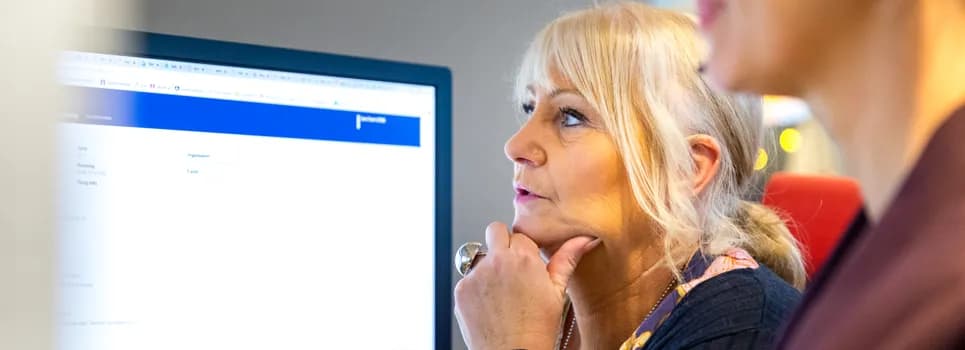 En kvinna sitter framför en datorskärm.