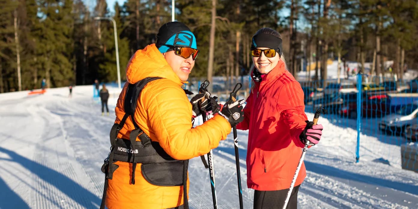 Några personer som står på toppen av en snötäckt sluttning.